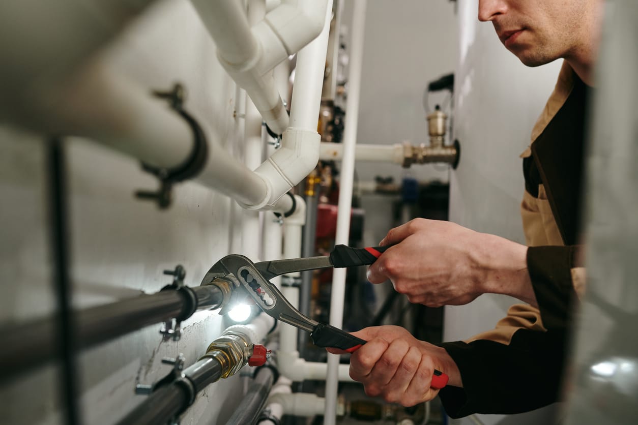 Plumbers maintaining commercial plumbing pipes in Camas