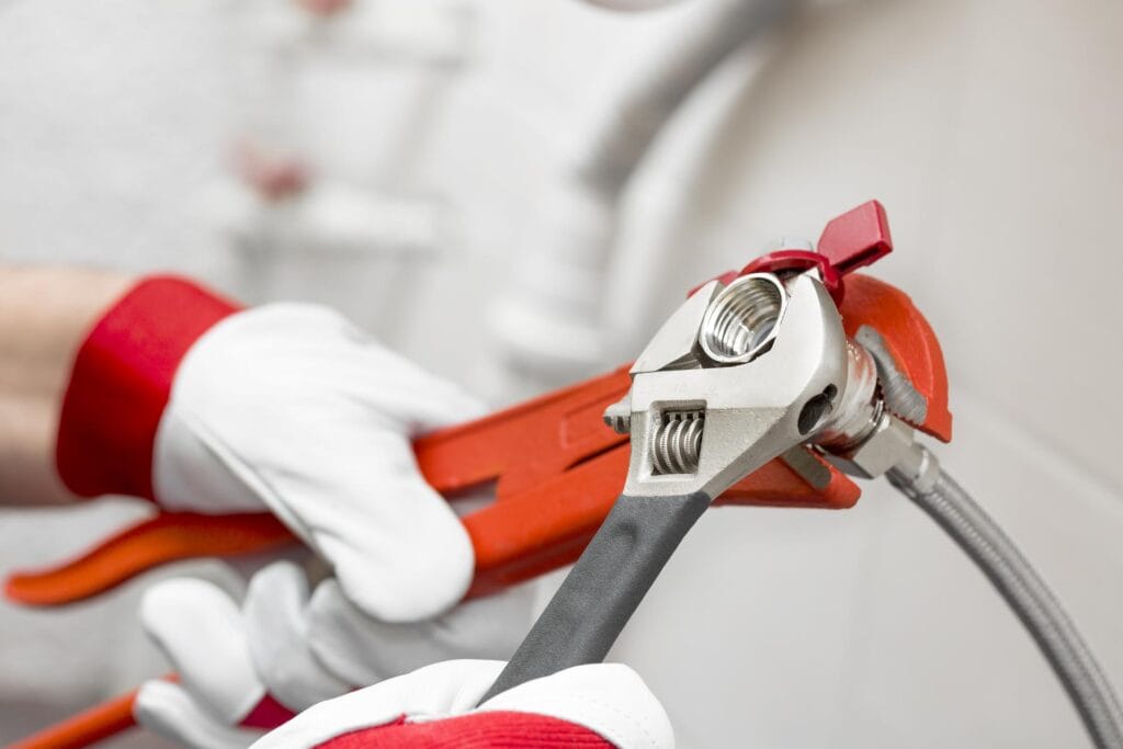 Plumber holding pipe wrenches for an emergency repair in Camas