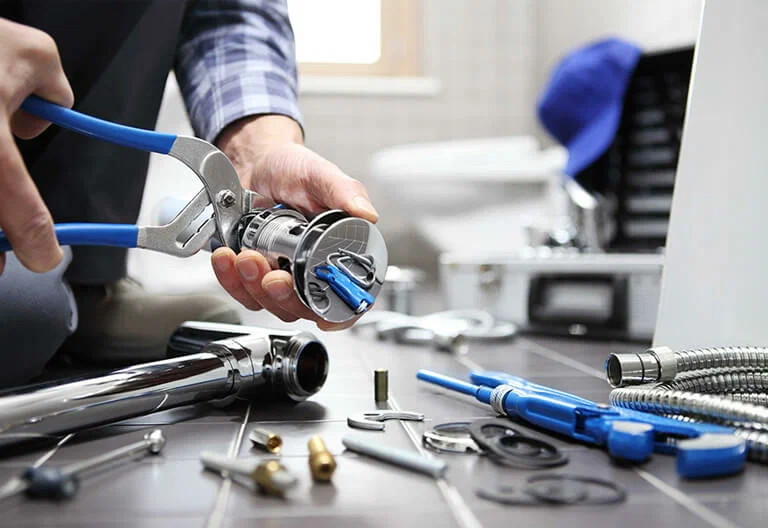 Technician repairing a plumbing fixture with professional tools in Camas