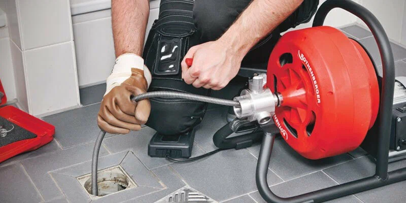 Plumber using a drain-cleaning machine in Camas