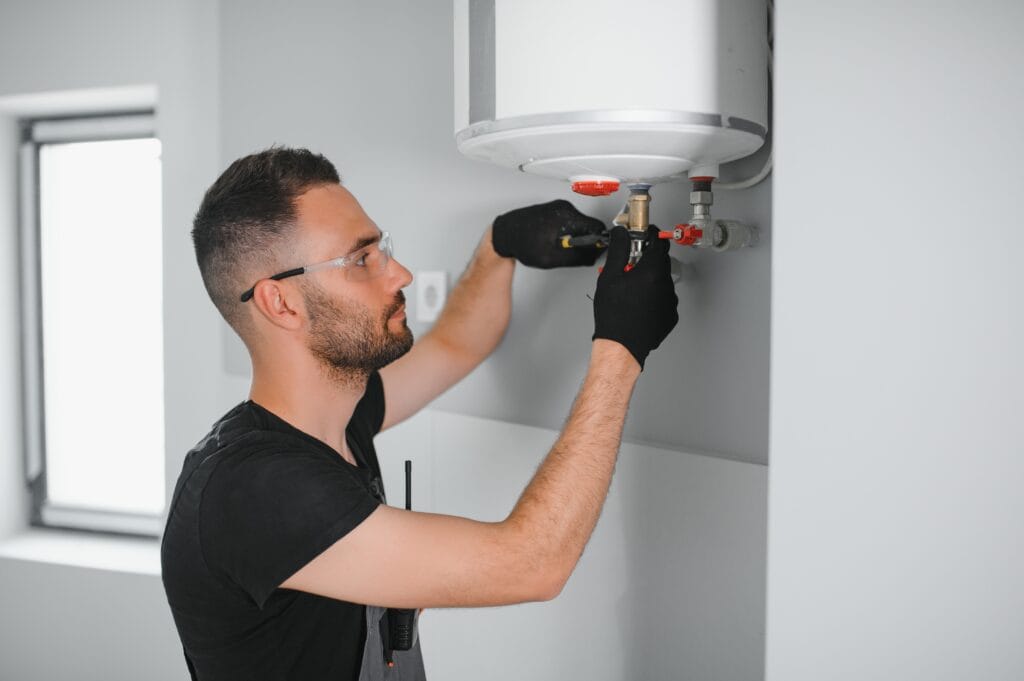 Technician performing water heater maintenance in Camas