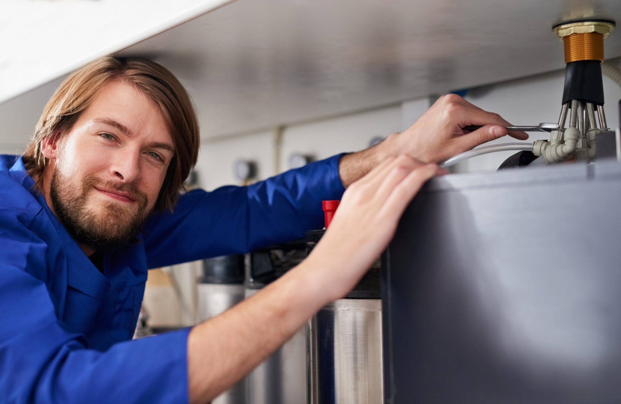 Technician servicing a residential water heater tank in Camas